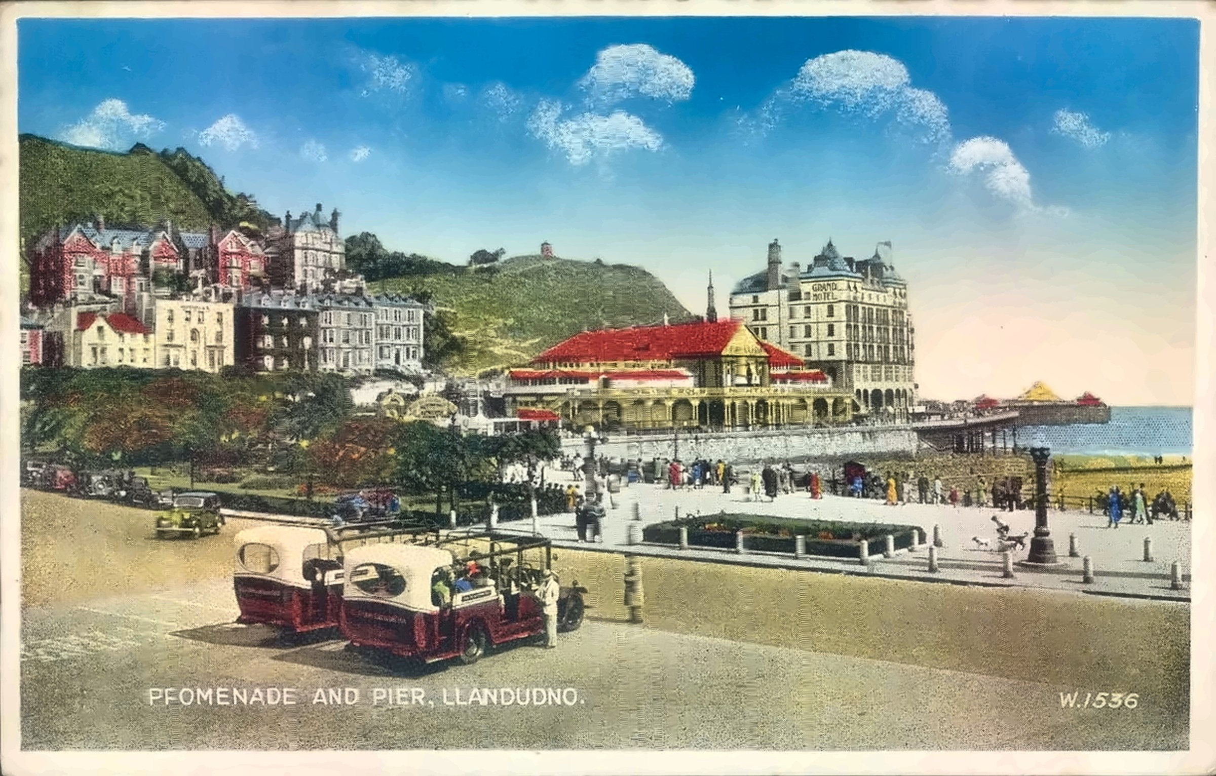 Vintage hand-tinted postcard of Llandudno promenade and pier, with the Great Orme behind